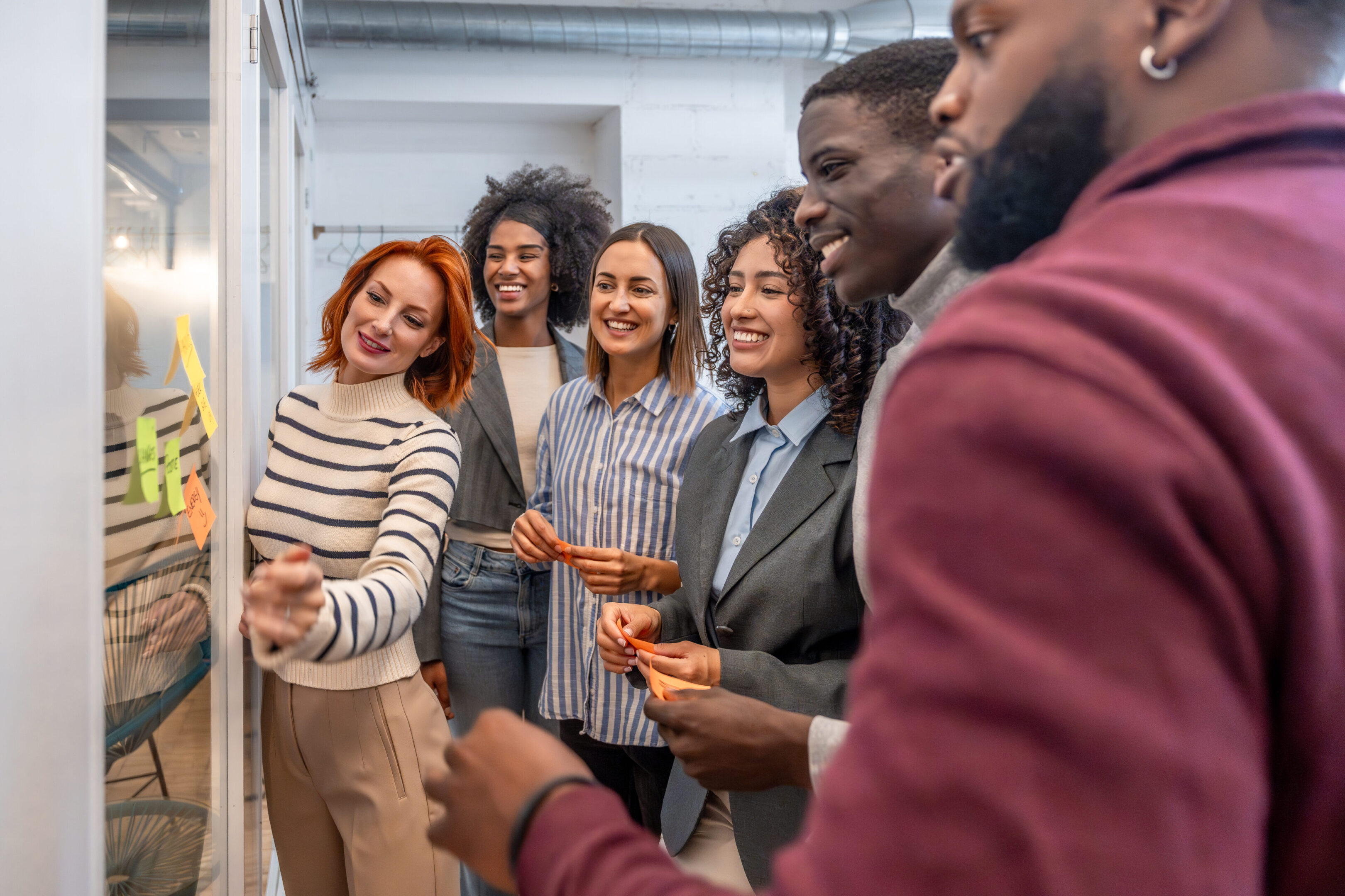 Coworkers during a brainstorming creative process in the office Side view of diverse males and females coworkers during a brainstorming creative process in the office